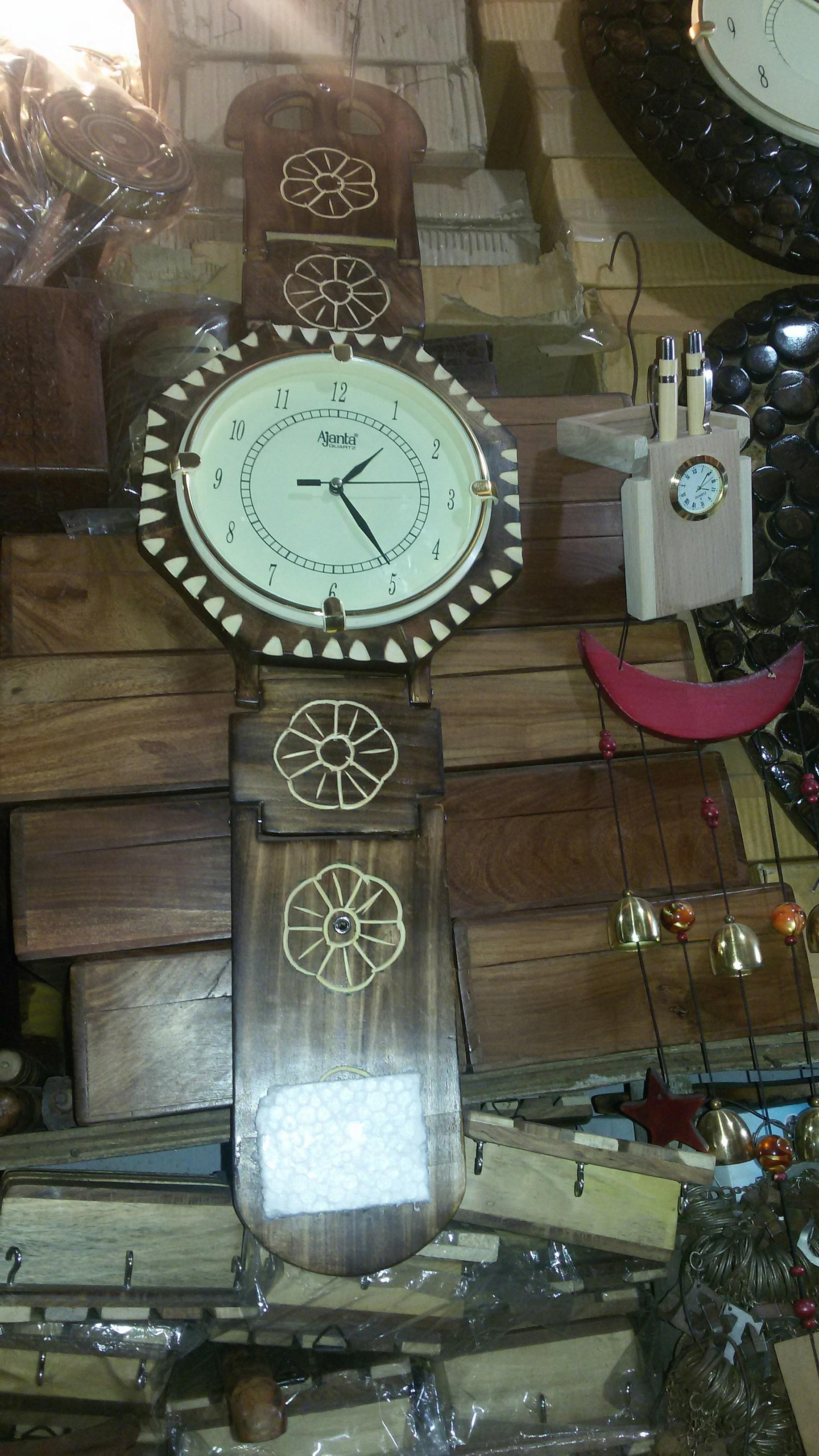 Tall wooden grandfather clock with ornate carved details and brass pendulum