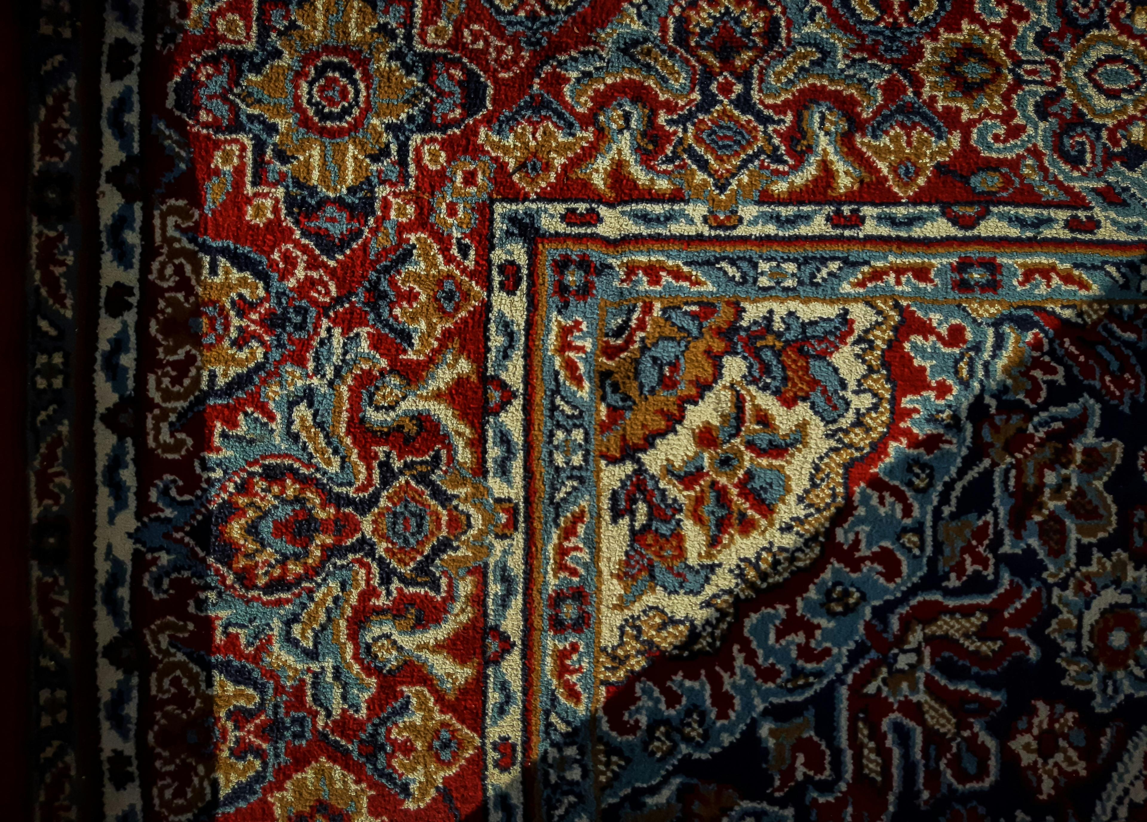 Hand-woven Persian rug with intricate floral patterns in red and blue tones